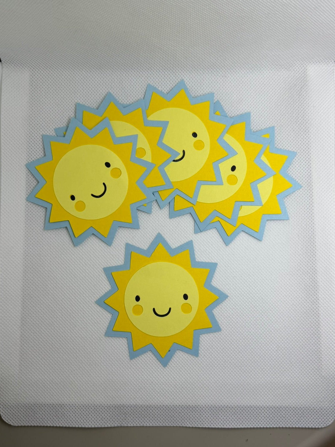 Pack of sun-shaped stickers with smiling faces on a white background.